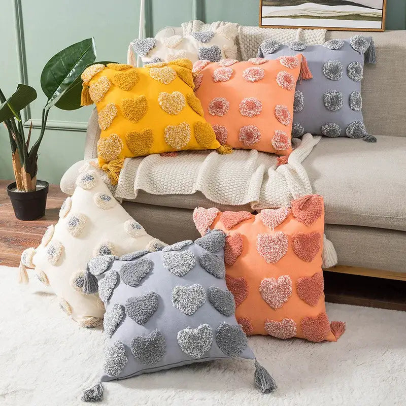 Vibrant cushion cover with boho tufted embroidered design in grey beige featuring heart-shaped pom-poms and tassels