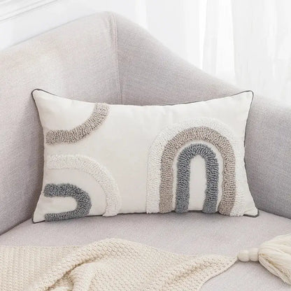 Cream-colored rectangular cushion cover with textured boho tufted embroidered rainbow design in grey and beige