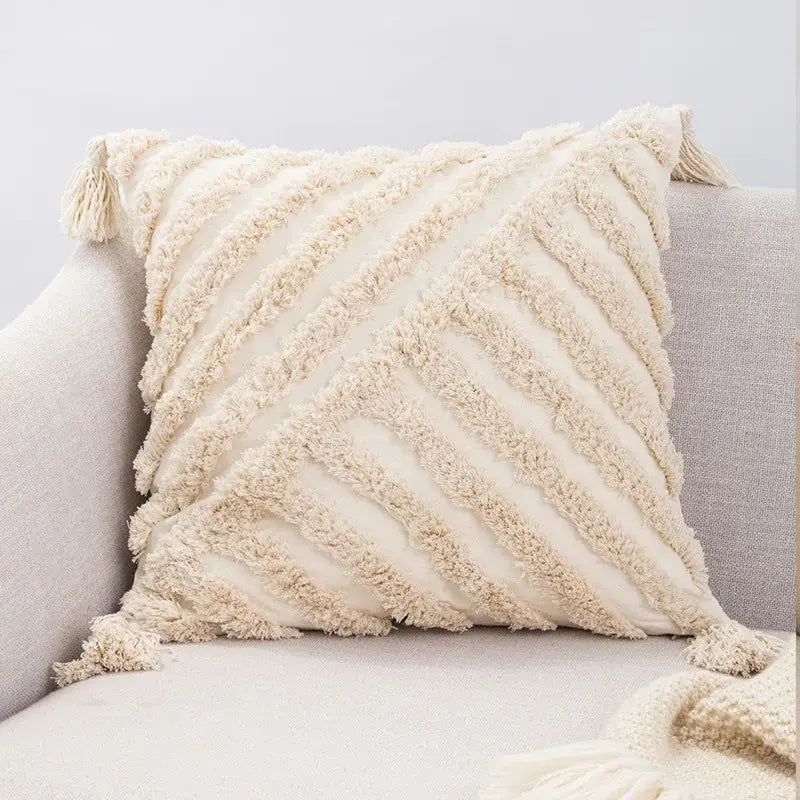 Cream-colored boho tufted embroidered cushion cover with textured diagonal ribbing and tassels for living room decorbites