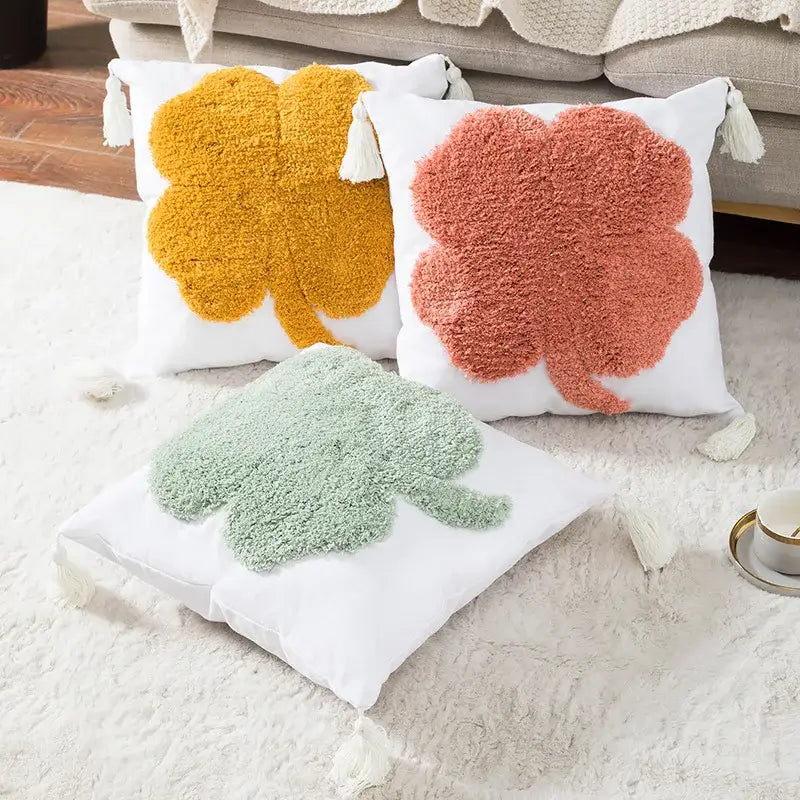 Three cozy throw pillows with plush shamrock design in mustard yellow coral pink and mint green on white cushion cover decorbites boho tufted embroidered