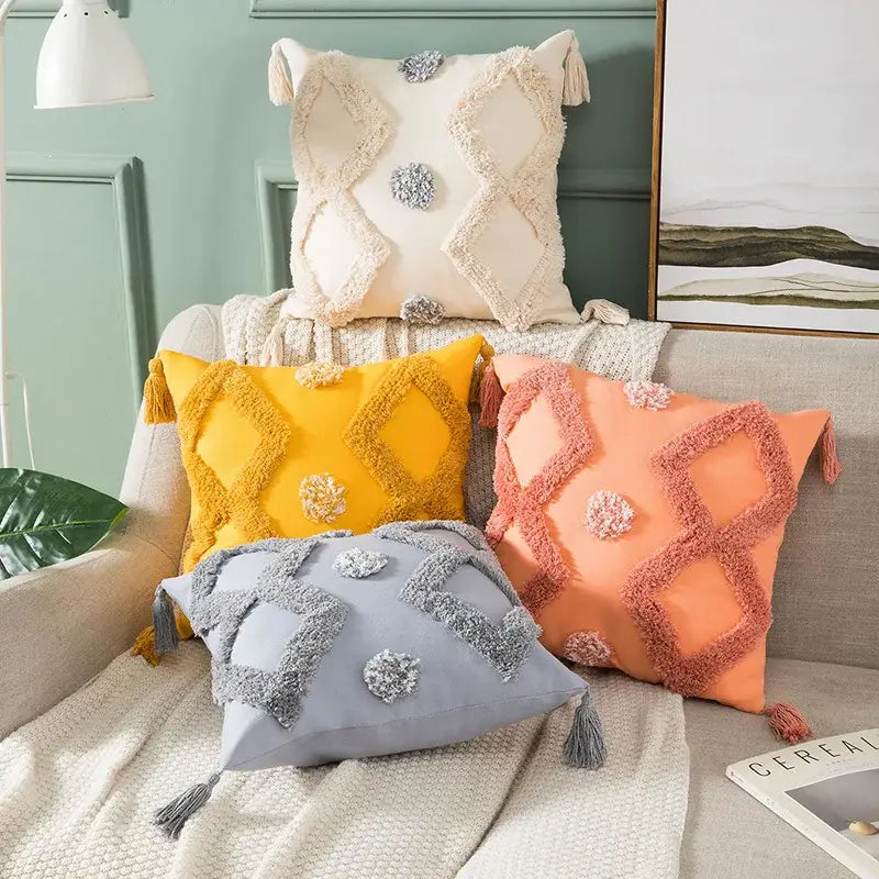 Cream yellow peach and gray boho tufted embroidered cushion cover with textured diamond patterns tassels and pom-poms