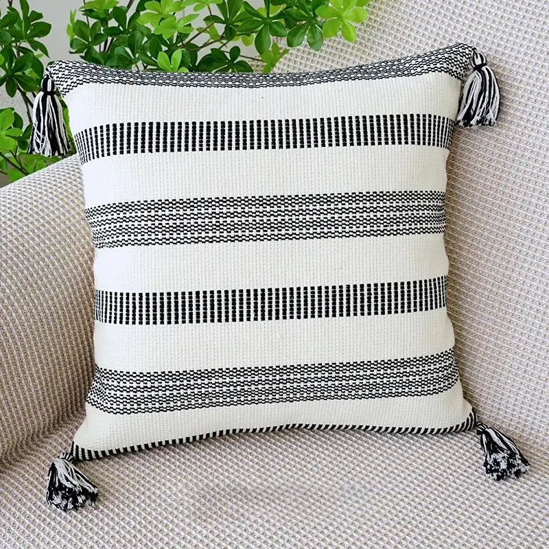Boho tufted fringed black and white striped woven throw pillow with tassels for living room decor by decorbites
