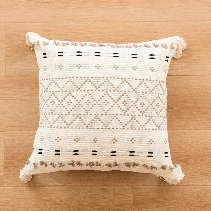 Cream-colored woven boho tufted fringed pillow with black and beige geometric patterns for living room decorbites decor
