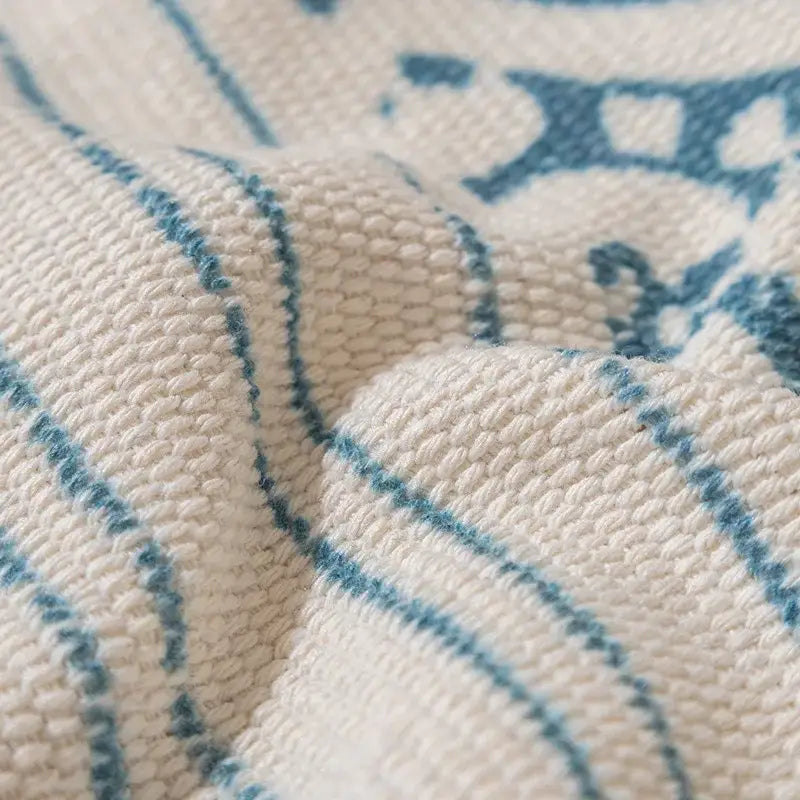 Cream-colored woven boho tufted fringed pillowcase with textured ribbed surface and subtle blue geometric patterns for decorbites