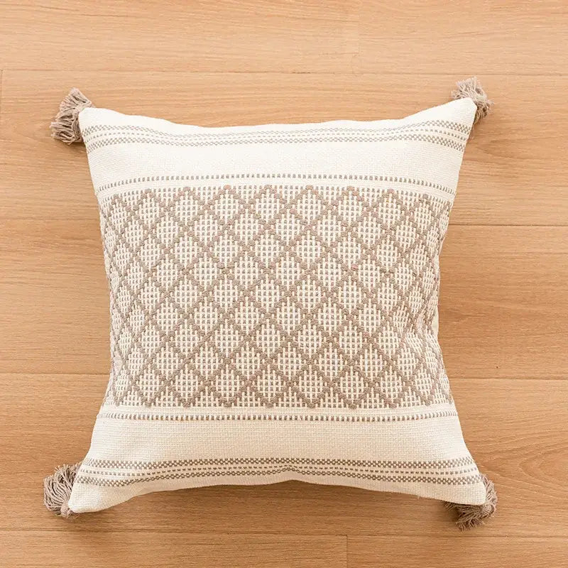 Cream-colored woven throw pillow with beige geometric diamond pattern and fringed tassels for decorbites boho tufted fringed decor