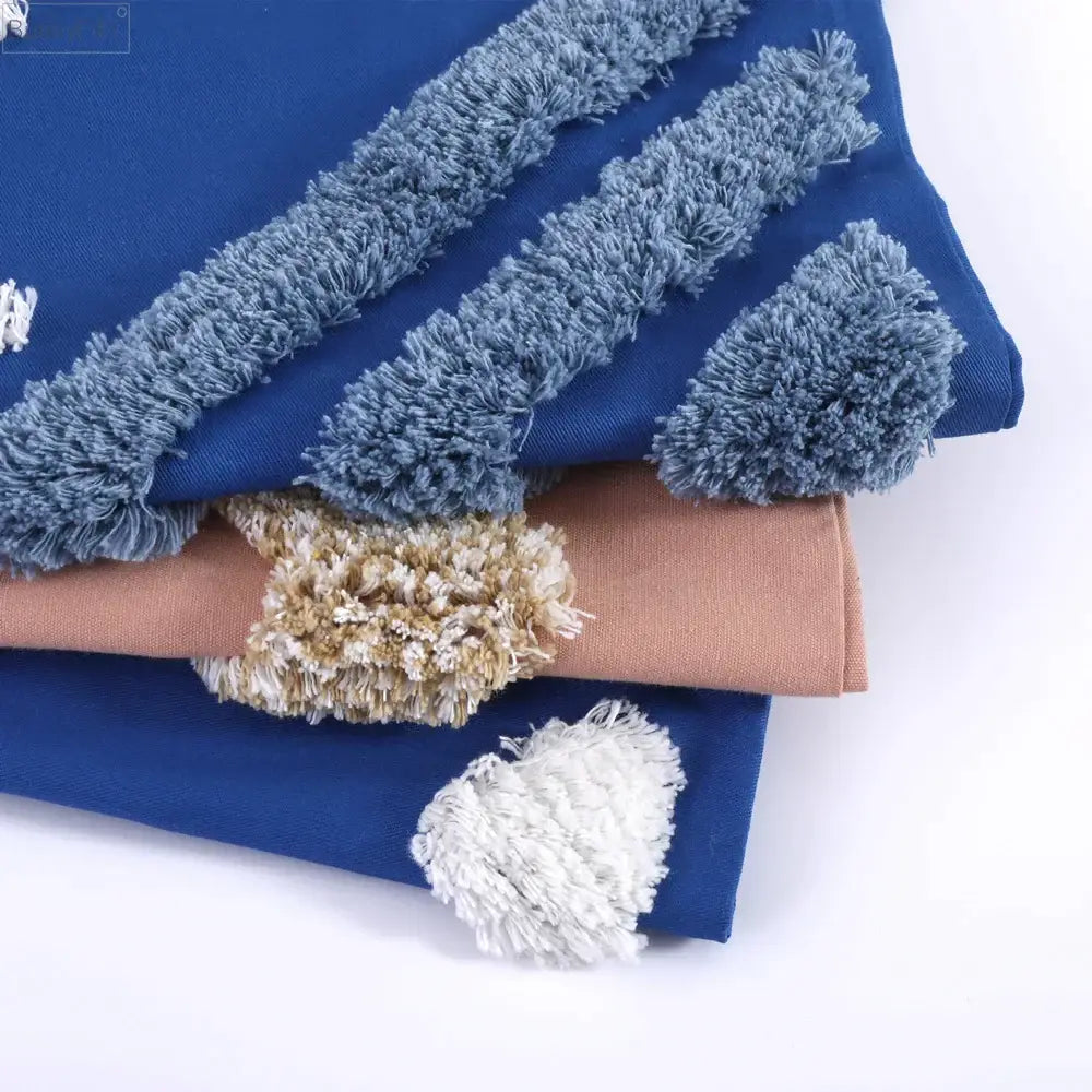 Stacked blue and beige fabric pieces with textured fluffy tassel trim for decorbites boho tufted cushion cover decor