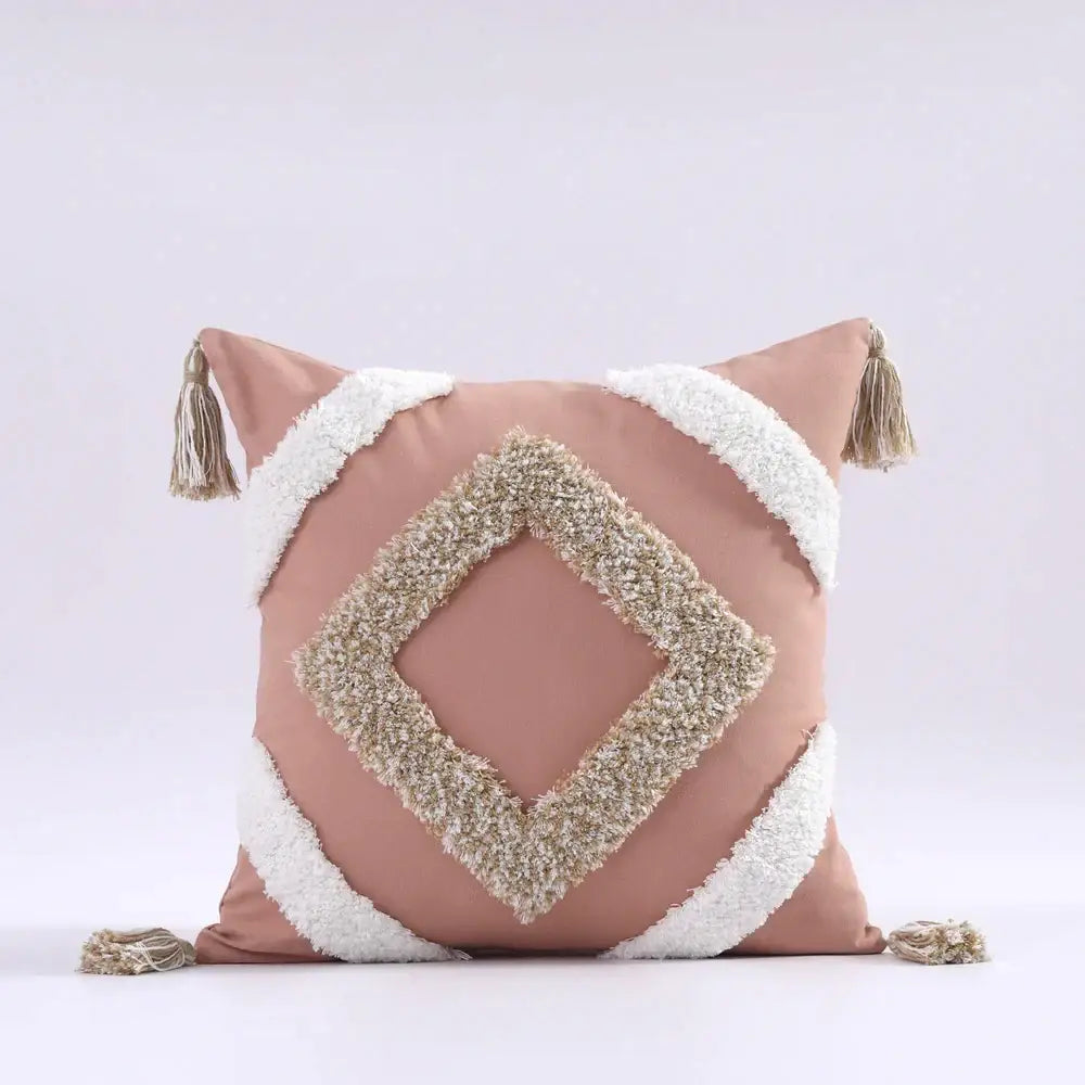 A blush pink boho tufted tassel cushion cover with cream diamond texture and matching tassels for living room decor