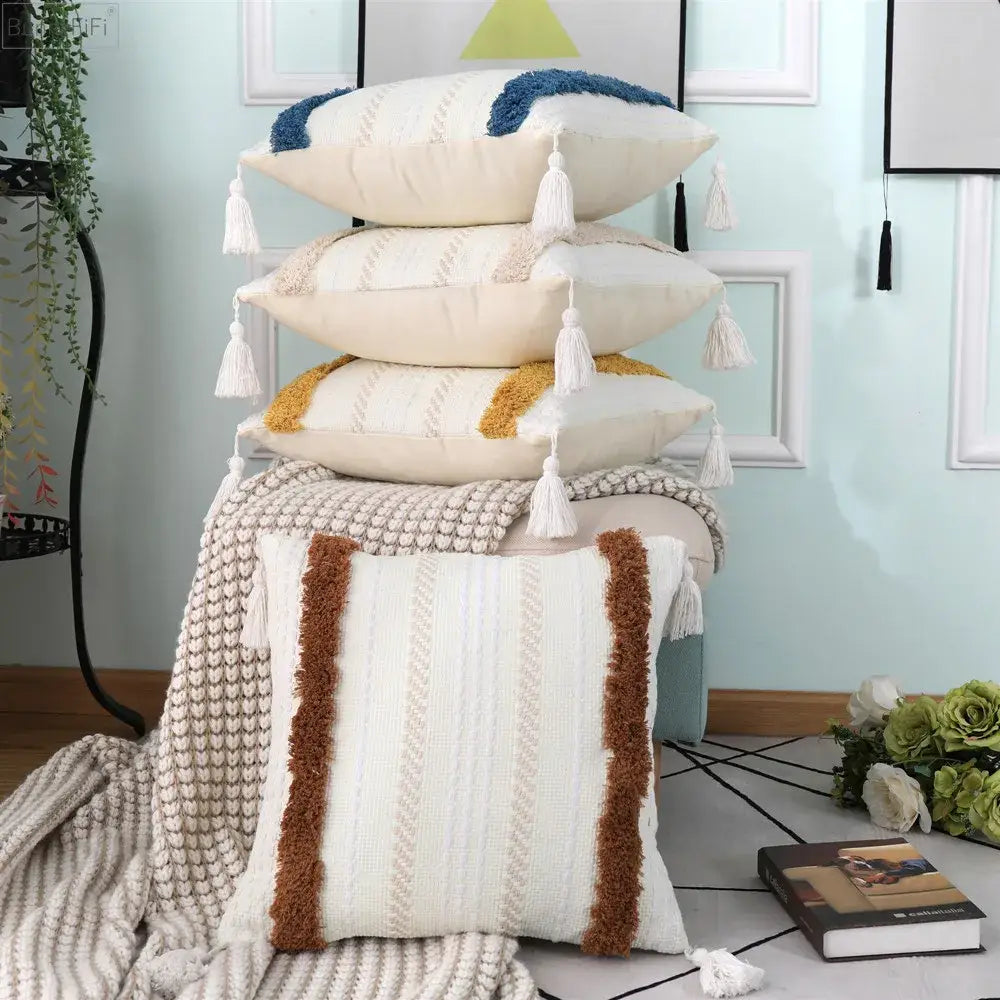 Stack of cream and beige boho woven tassel pillow cases with textured fringe and woven patterns for living room decorbites decor