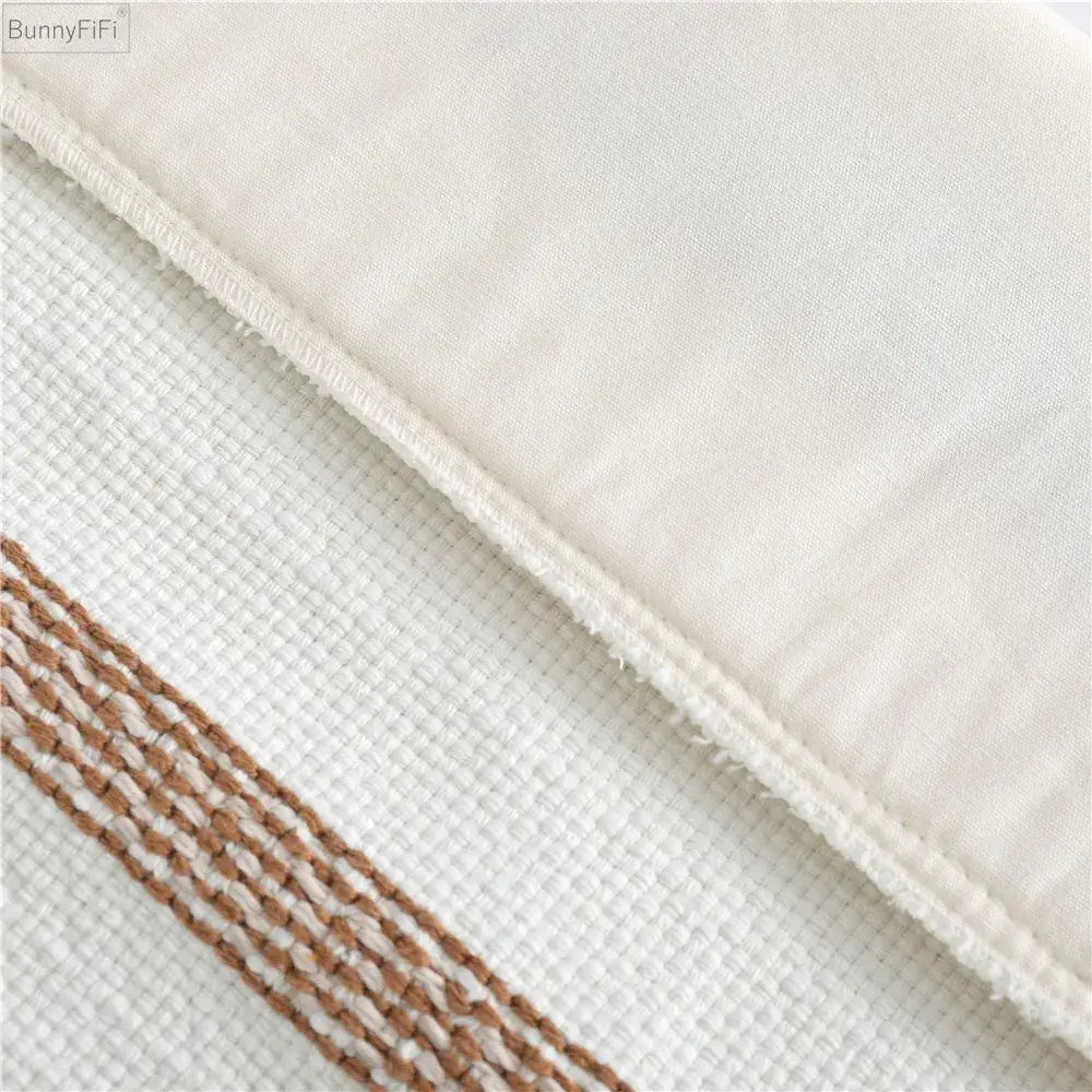 White textured fabric pillow case with brown and white woven stripe border boho woven tassel decorbites design
