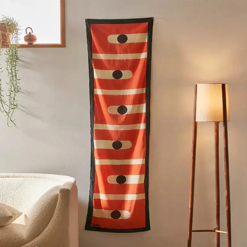 Vibrant orange silk scarf with cream stripes and black accents, featuring celestial geometry tapestry design for decorbites