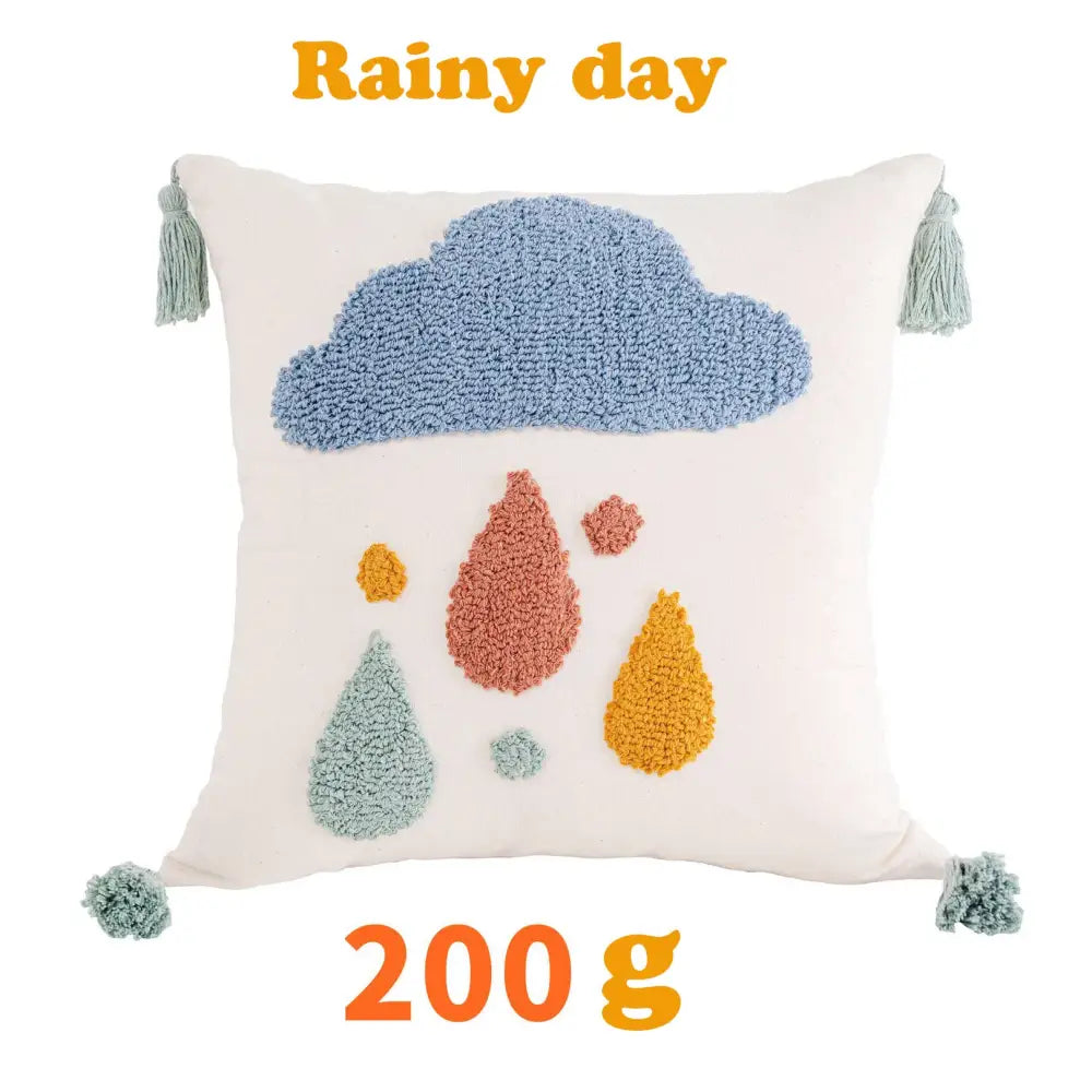 Cream-colored cushion cover with textured blue cloud multicolored raindrop appliqués and light green tassels decorbites boho yellow