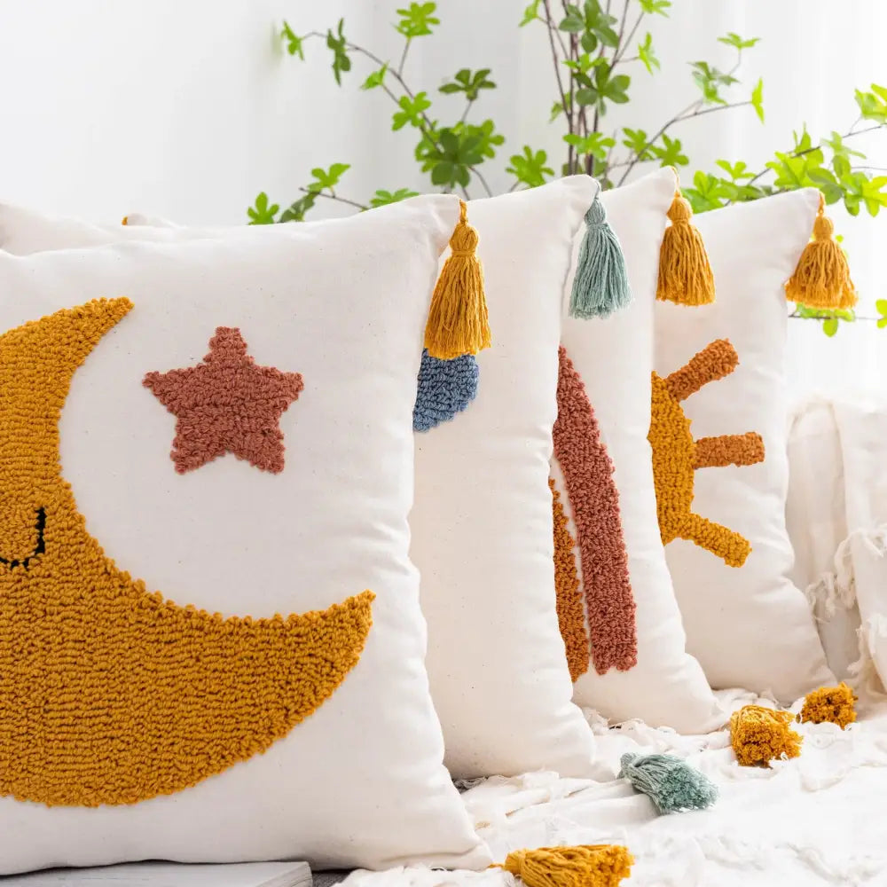White cushion cover featuring a textured mustard-yellow crescent moon and star with colorful tassels decorbites boho yellow decor