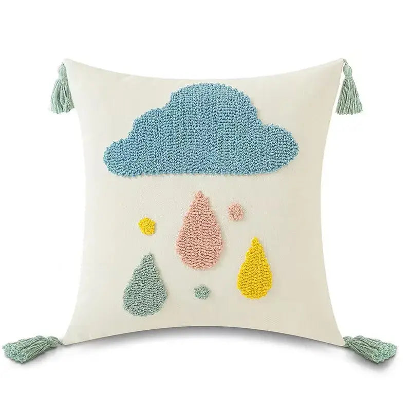 Cream-colored pillow cover with textured blue cloud, colorful embroidered raindrops, and teal tassels decorbites boho yellow rainbow