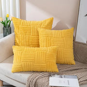 Three vibrant yellow plush throw pillow covers with a textured woven pattern arranged on a cozy sofa for living room decor