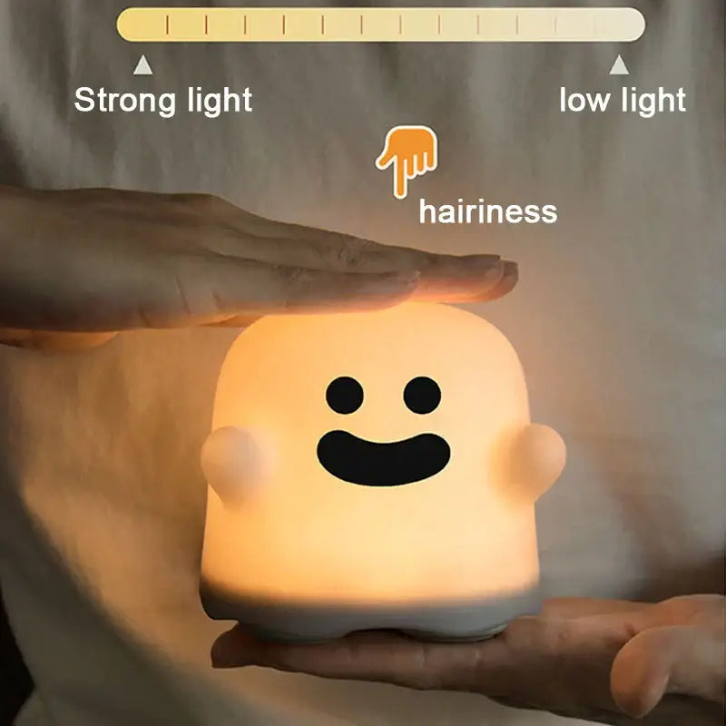 A soft glowing orange boo ghost silicone lamp with a smiling face designed as a bedroom led night light decorbites boo ghost