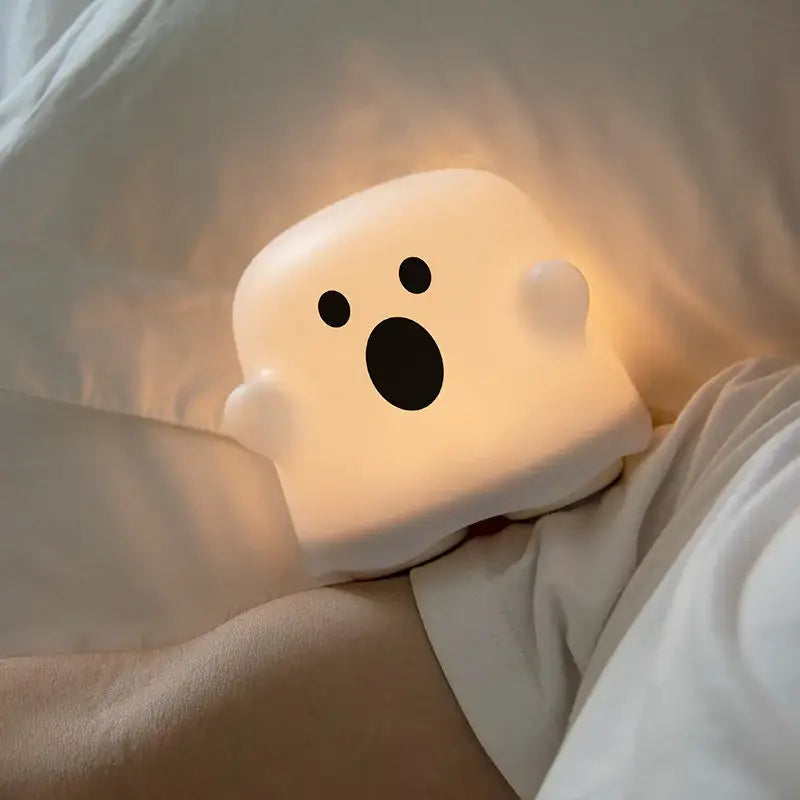 A soft glowing white boo ghost silicone lamp with black eyes and mouth perfect as a bedroom LED night light decorbites boo ghost