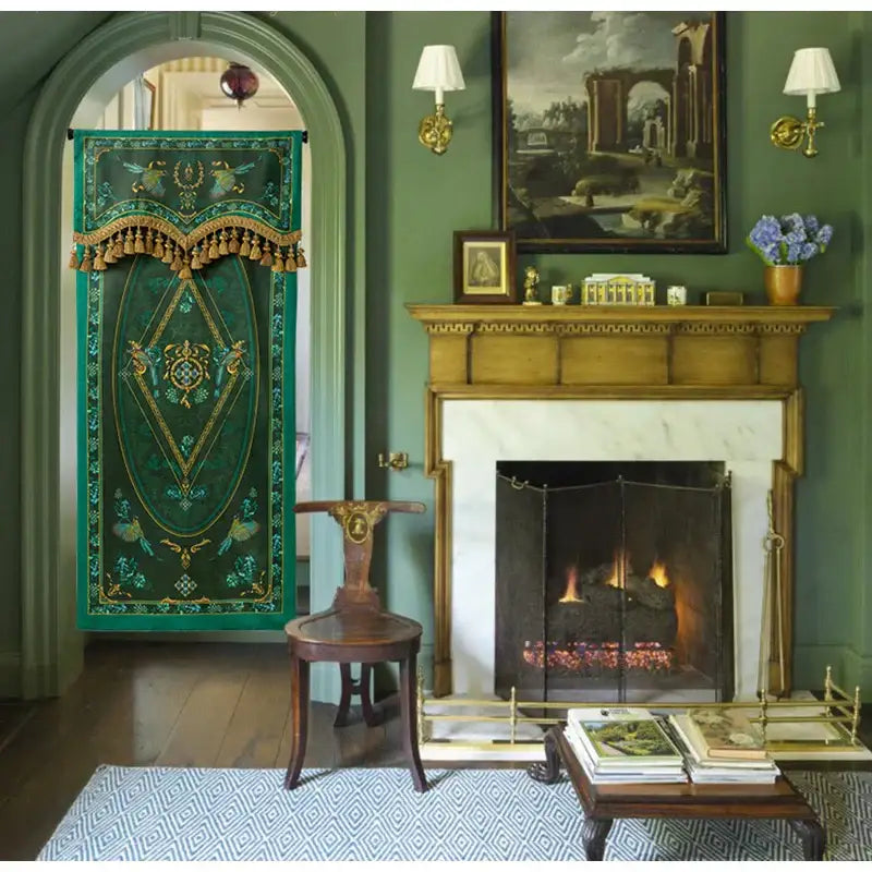 Emerald green botanic garden velvet blackout curtain with gold thread embroidery and tassel trim hanging in arched doorway