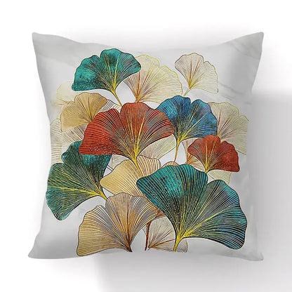 A square throw pillow with vibrant teal red gold and cream ginkgo big leaves on light gray cushion cover for living room