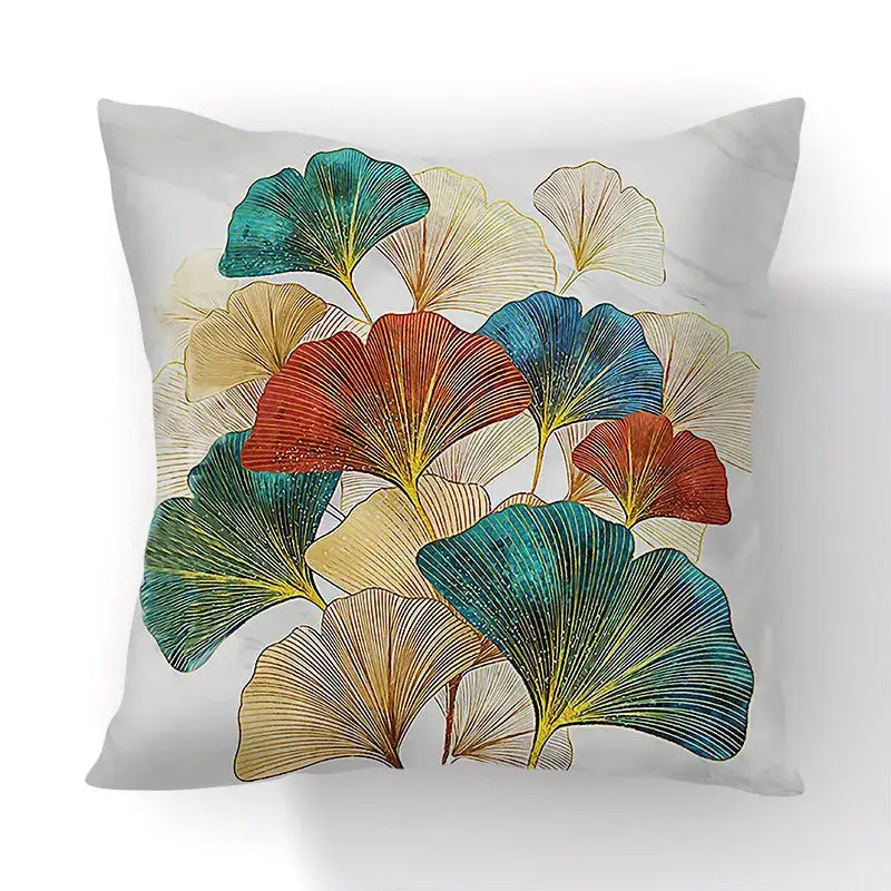 A square throw pillow with vibrant teal red gold and cream ginkgo big leaves on light gray cushion cover for living room