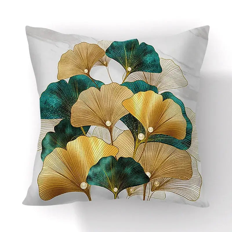 A square throw pillow with golden and teal big leaves on a white marble background for living room cushion covers
