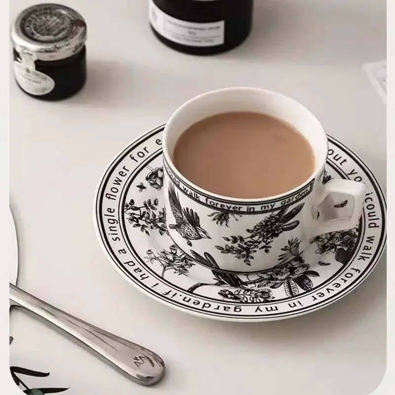 White ceramic bird ceramic coffee cup and saucer set with black botanical illustrations and decorbites black bird design