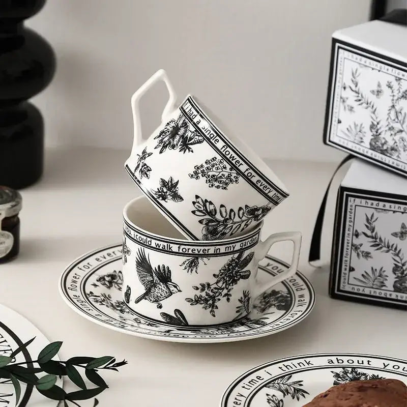White ceramic bird ceramic coffee cup and saucer set with black botanical decorbites black bird illustrations and phrases