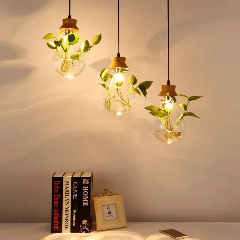 Three hanging pendant lights with clear botanical glass bottle bulbs and wood accents casting a warm glow decorbites botanical glass