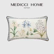 Cream-colored linen lumbar pillowcase with embroidered botanical leaf watercolor design in blue pink and green for bedroom decor