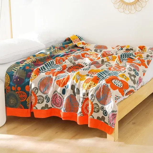 A decorbites cotton leisure blanket featuring bold orange teal and pink floral motifs on off-white cotton for bedroom use