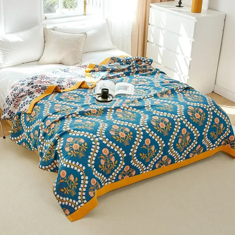 A teal floral-patterned decorbites cotton leisure blanket with gold white accents and a bold yellow border for bedroom use