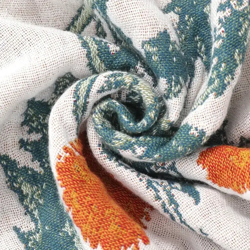 A soft white knitted cotton leisure blanket with vibrant teal and orange abstract patterns from decorbites cotton leisure
