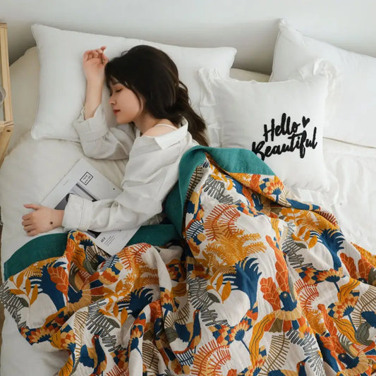 A cozy cotton gauze blanket bedspread with vibrant orange and blue botanical design for decorbites birds plaid decor