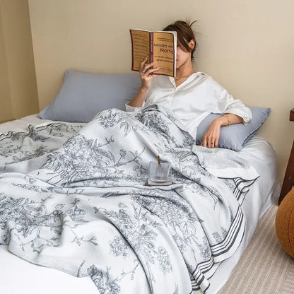 A soft white and gray floral summer quilt made from bamboo four layer fabric draped over a bed for decorbites bamboo four