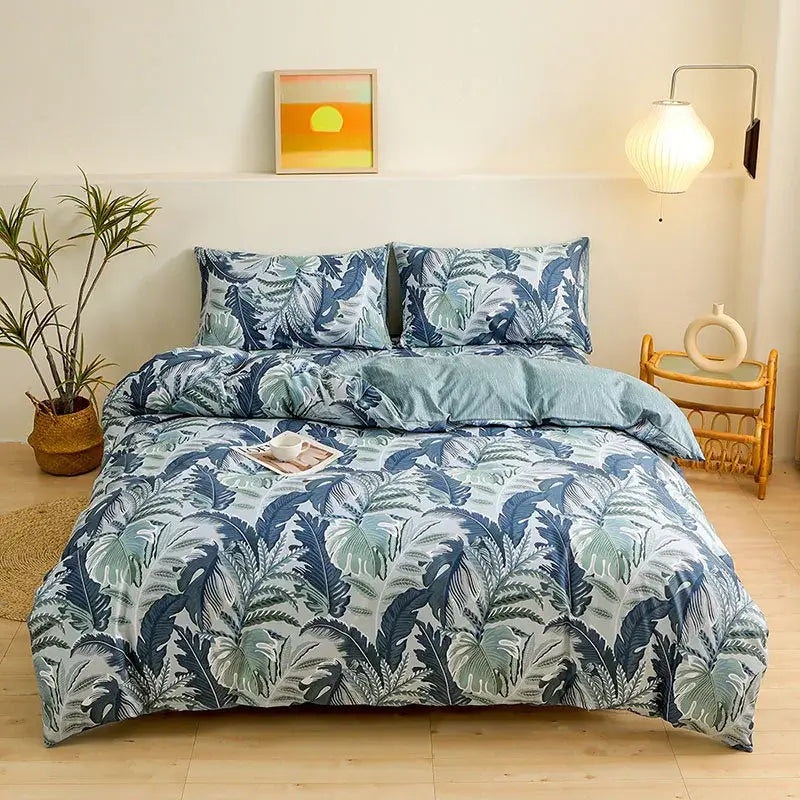 Blue and green tropical leaf patterned duvet cover set complementing botanical yellow and white floral bedroom bedding