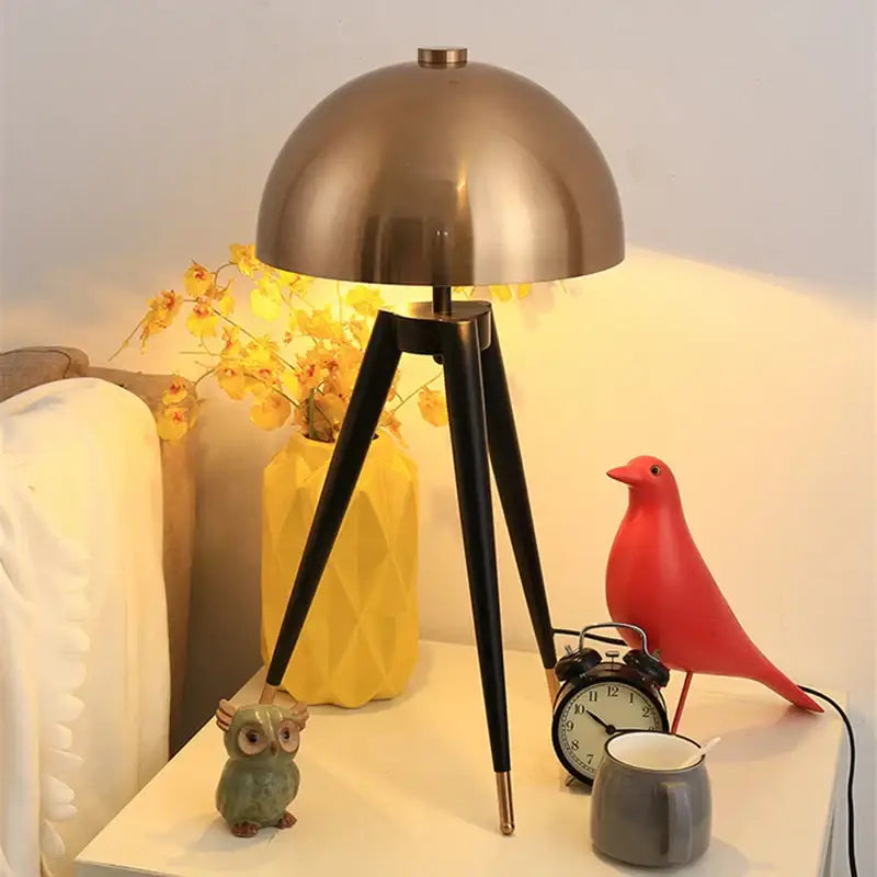 Bronze dome-shaped brass and black decorbites coyote gold tripod floor lamp with black tripod legs for living room decor
