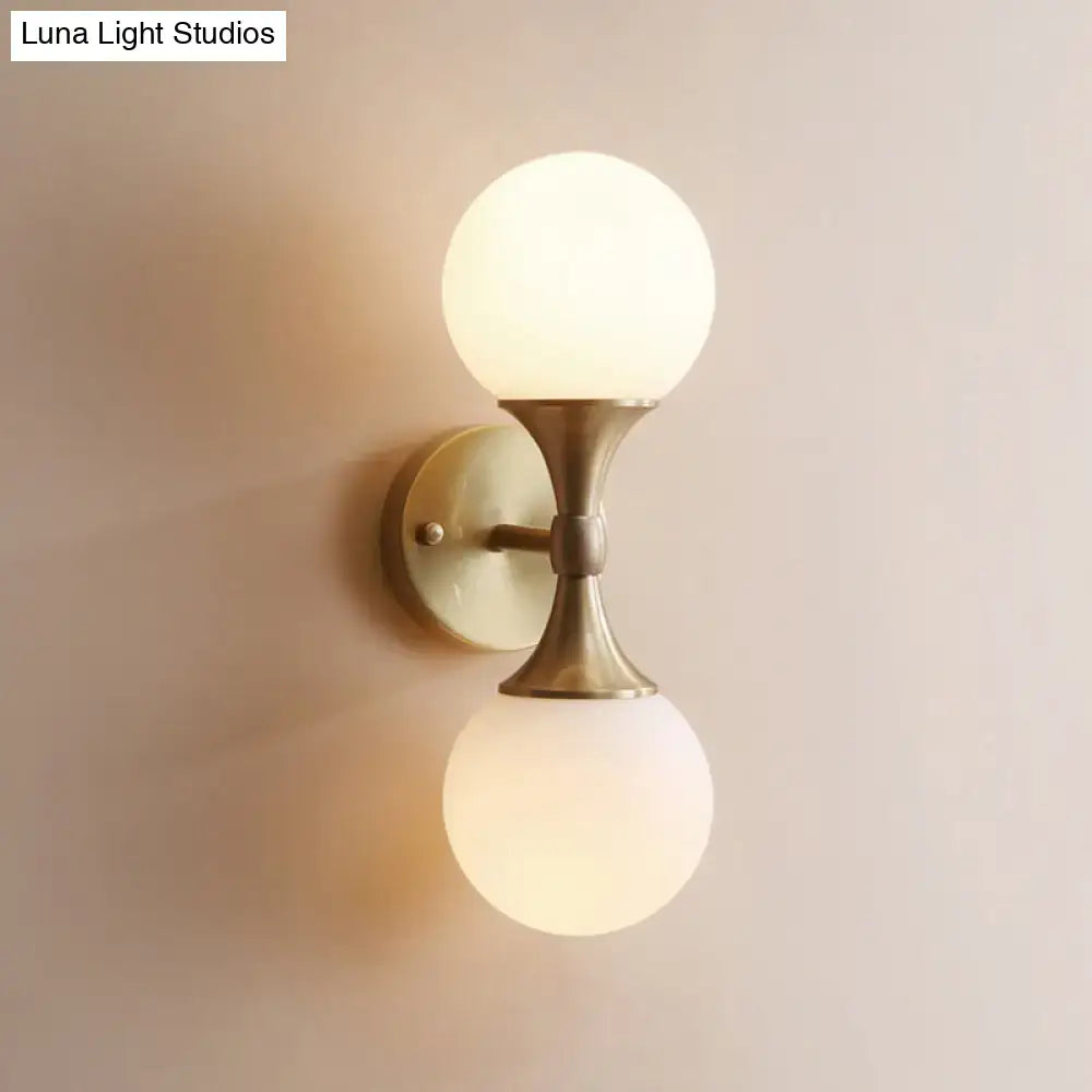 DecorBites ivory glass ball wall lamp with 2-head brass sconce and frosted glass globes designed as a stylish wall lamp