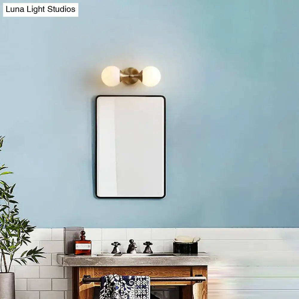 Rectangular mirror with sleek black frame alongside decorbites ivory glass ball wall lamp with 2-head brass sconce for bedroom