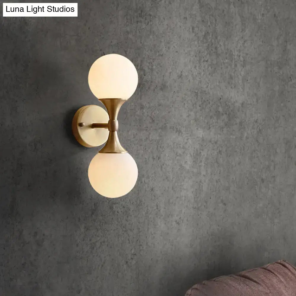 DecorBites™ ivory glass ball wall lamp with 2-head brass sconce and frosted globe shades for bedroom lighting
