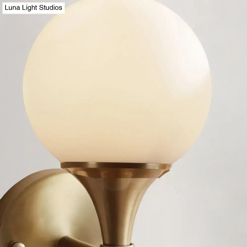 DecorBites™ ivory glass ball wall lamp with warm frosted globe and brass finished metal base for bedroom use