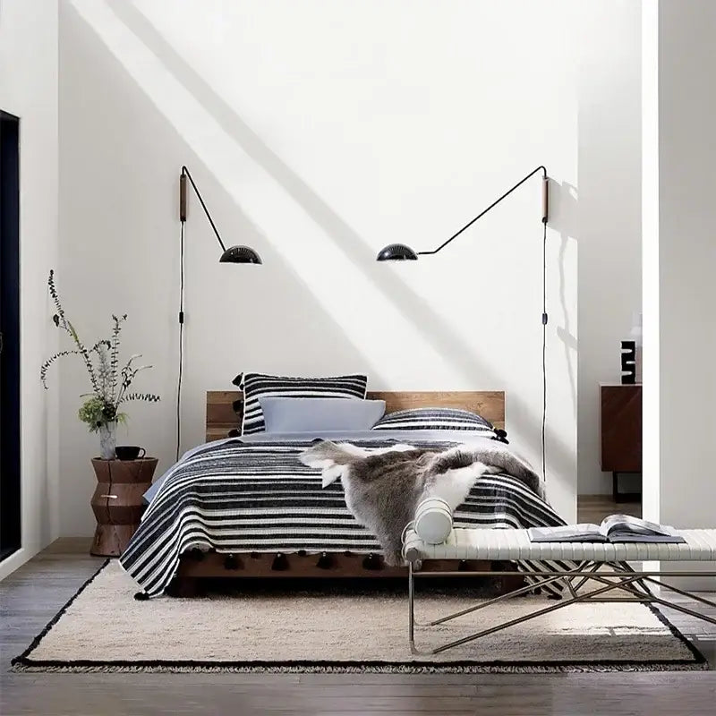 Black articulated wall lamp with adjustable metal wood arms and dome-shaped shades for bedroom reading light