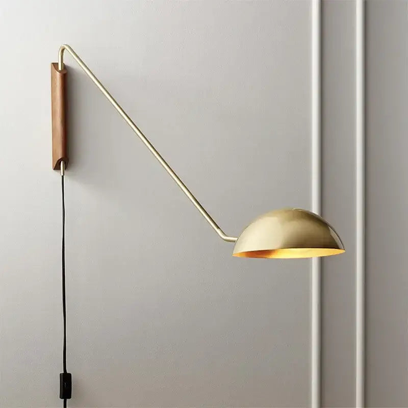 Gold-toned adjustable metal wood wall lamp with sleek articulated arm and wooden backplate for bedroom reading light