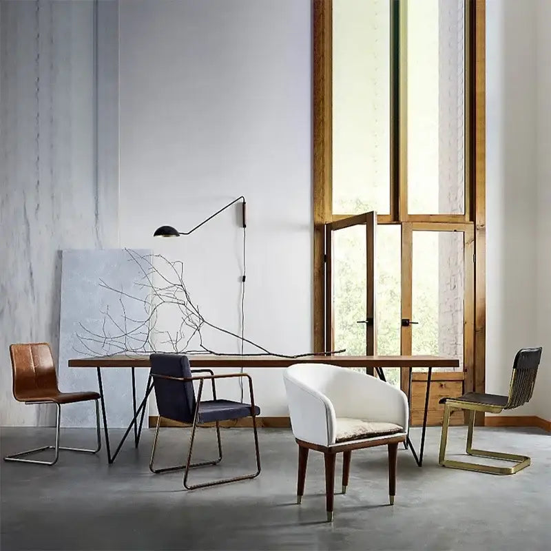 White upholstered armchair with wooden legs and cushioned seat beside a brass and wood adjustable metal wood wall lamp