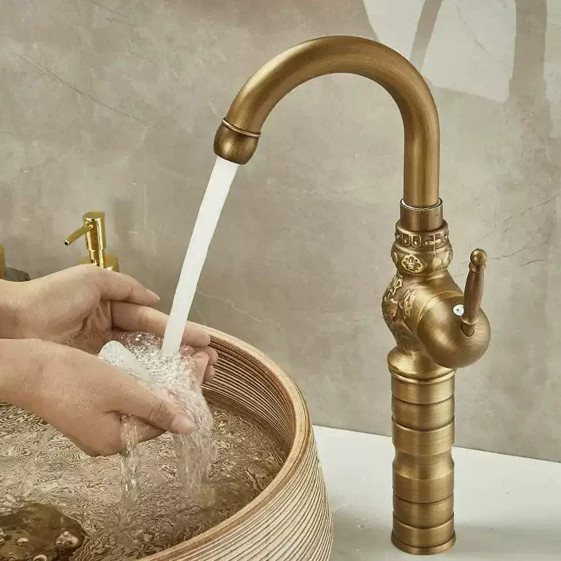 Brass antique bathroom sink faucet with ornate vintage design and curved spout in brass finish