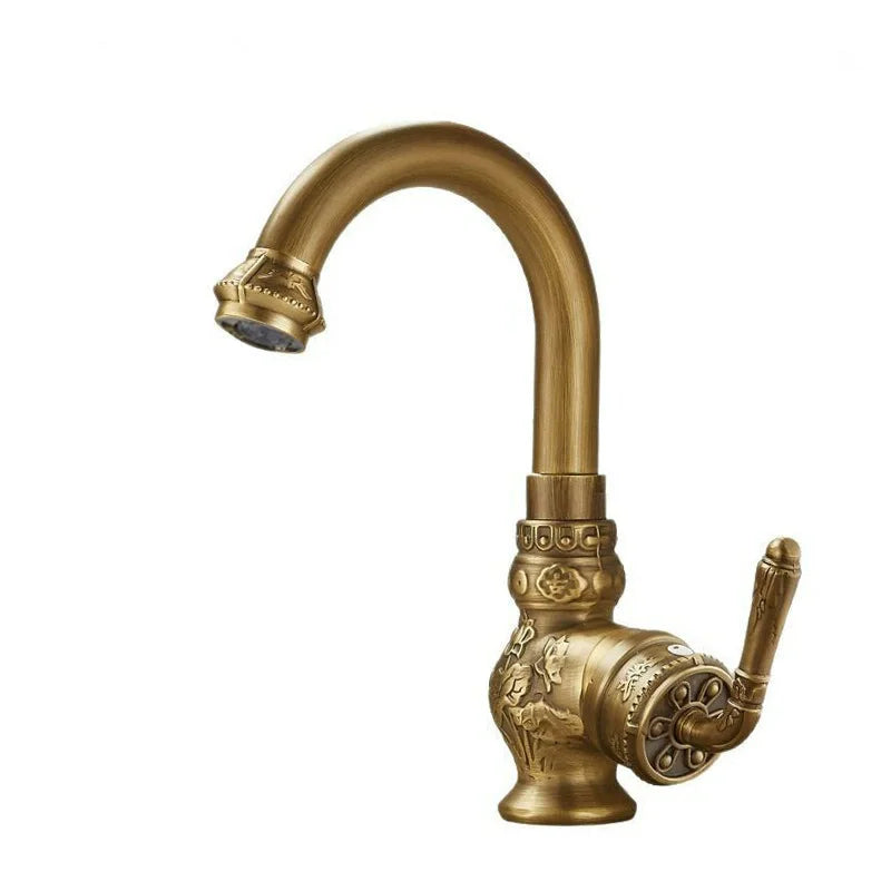 Brass antique bathroom sink faucet with ornate floral and scrollwork detailing in antique brass finish