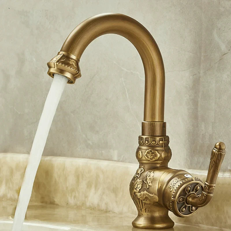 Brass antique bathroom sink faucet in antique brass with ornate floral and scrollwork detailing