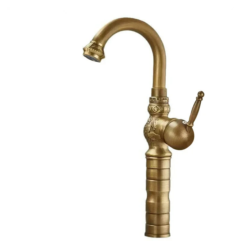 Brass antique bathroom sink faucet with ornate detailing and a curved spout in an antique brass finish