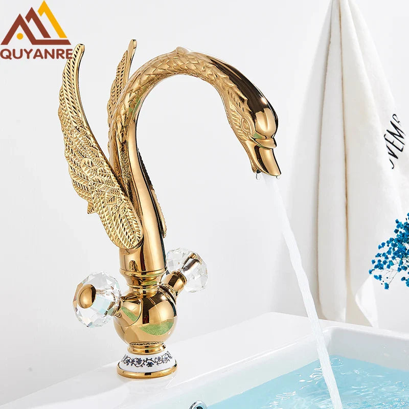 Brass basin faucet deck mounted shaped like a golden swan with intricate feather detailing and crystal knobs in antique brass