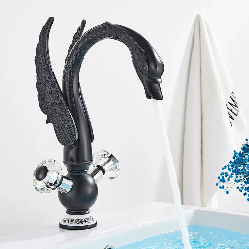 Black swan-shaped antique brass basin faucet with crystal knobs and ornate detailing deck mounted design