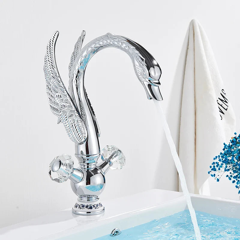 Chrome finished swan-shaped brass basin faucet with crystal knobs and detailed wing design for deck mounting