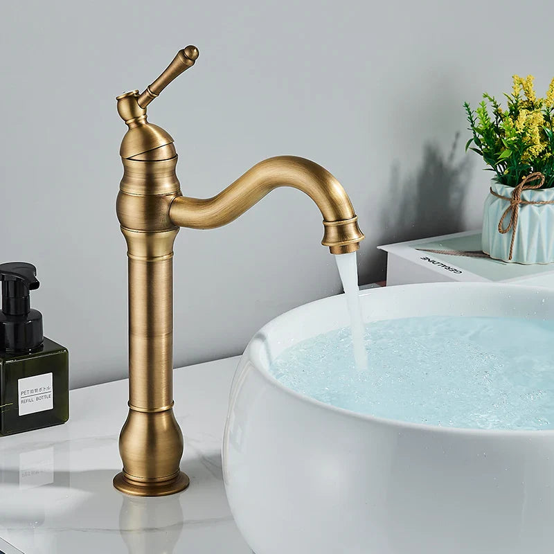 Antique brass-finished single-handle brass bathroom basin mixer faucet with curved spout and decorative ridged detailing